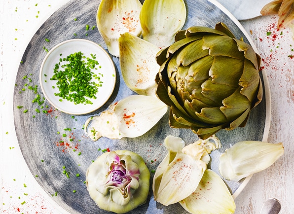 Assiette avec une déclinaison d'artichauts : artichaut entier, feuilles et coeurs d'artichaut